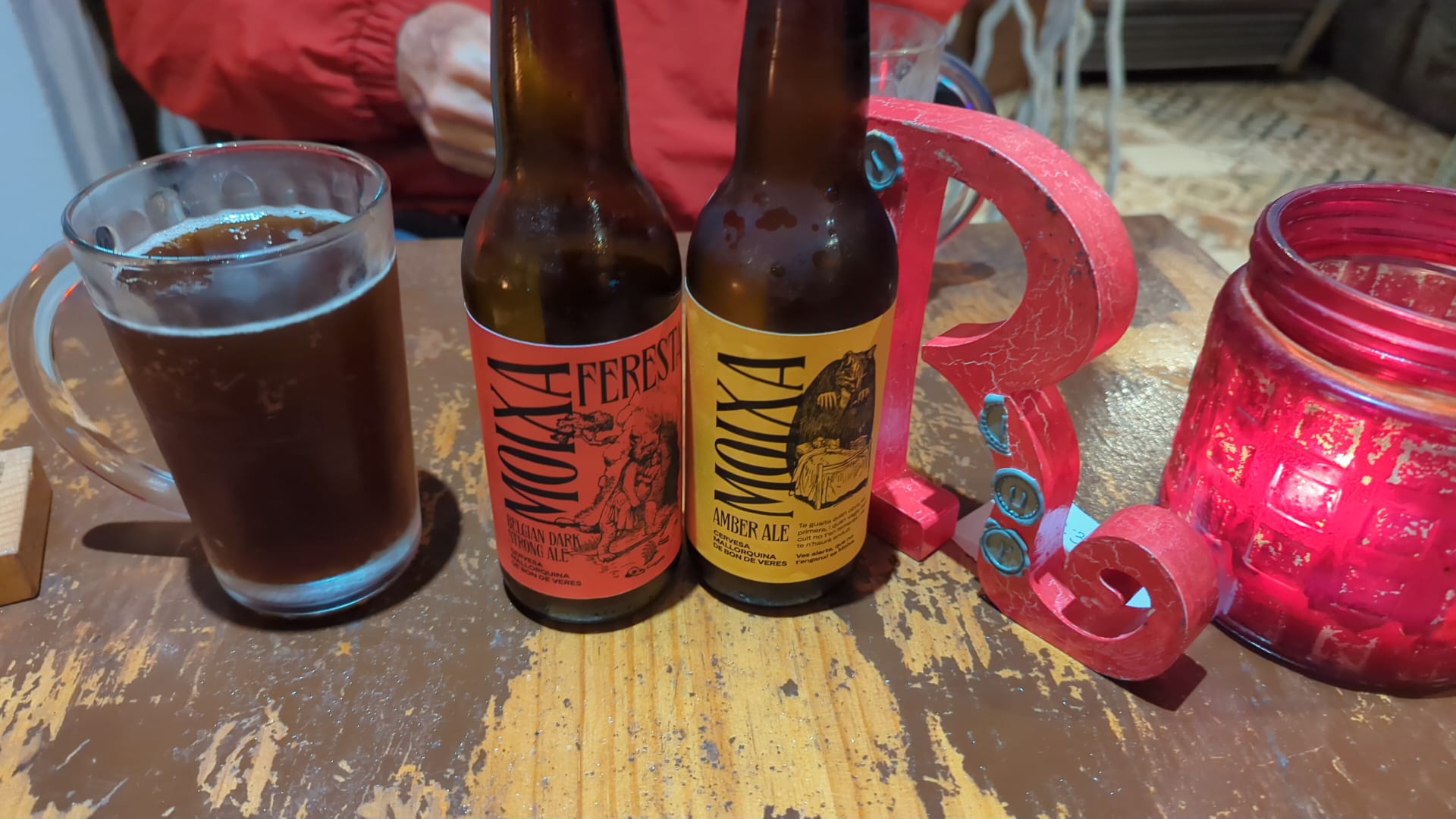 Foto amb les dues varietats de cervesa Moixa sobre una taula de fusta