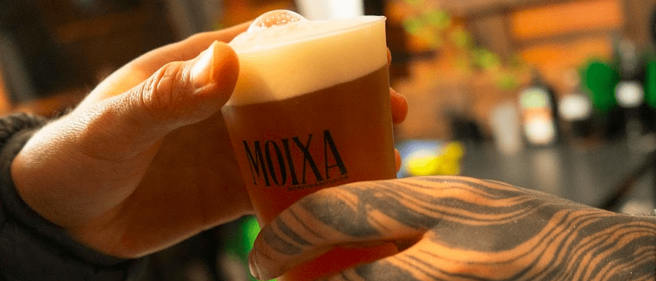 A wet beer bowl being handed to a consumer